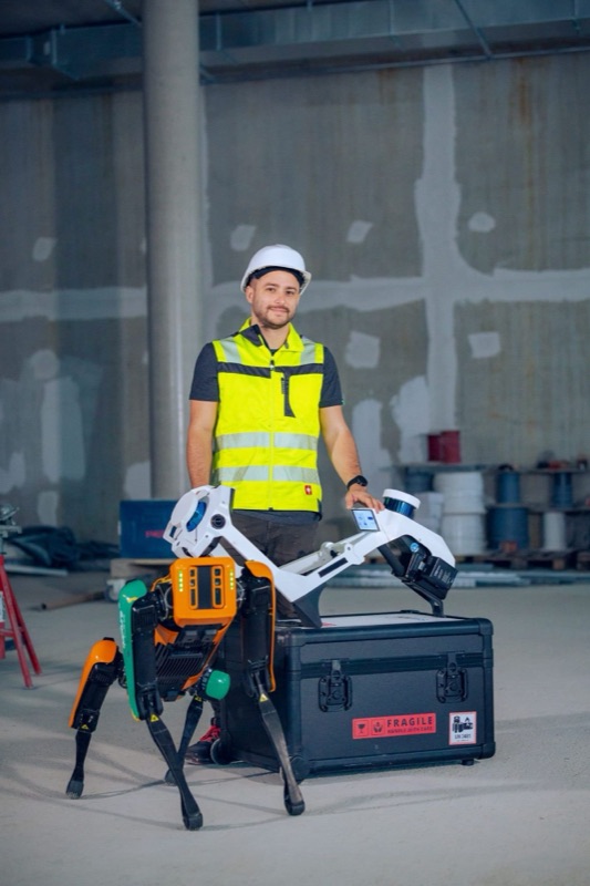 Colleague with the robot dog Spot and a mobile laser scanner on site